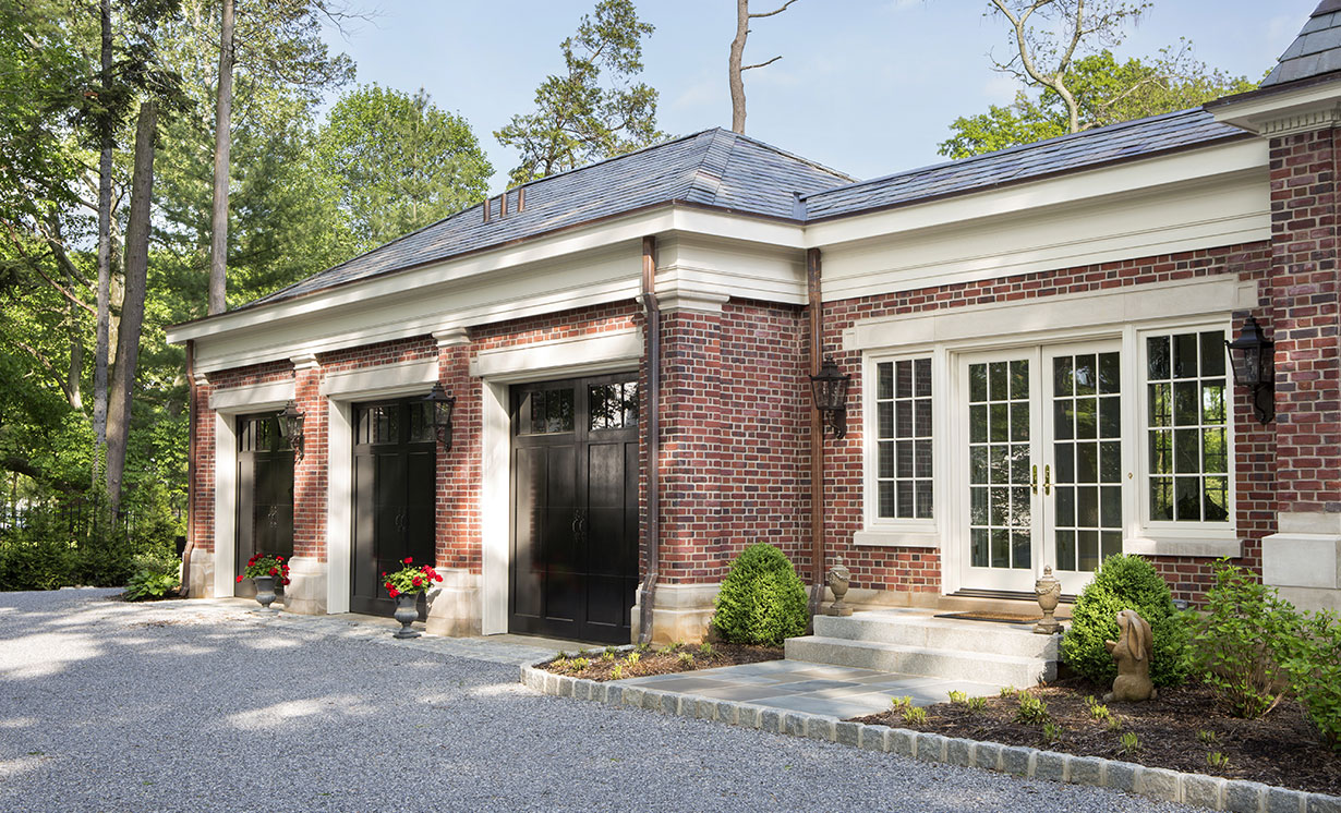 The new three-car garage and mudroom addition were designed and built by our design-build team. Great efforts were made to match the original brick and limestone trim of the existing home.