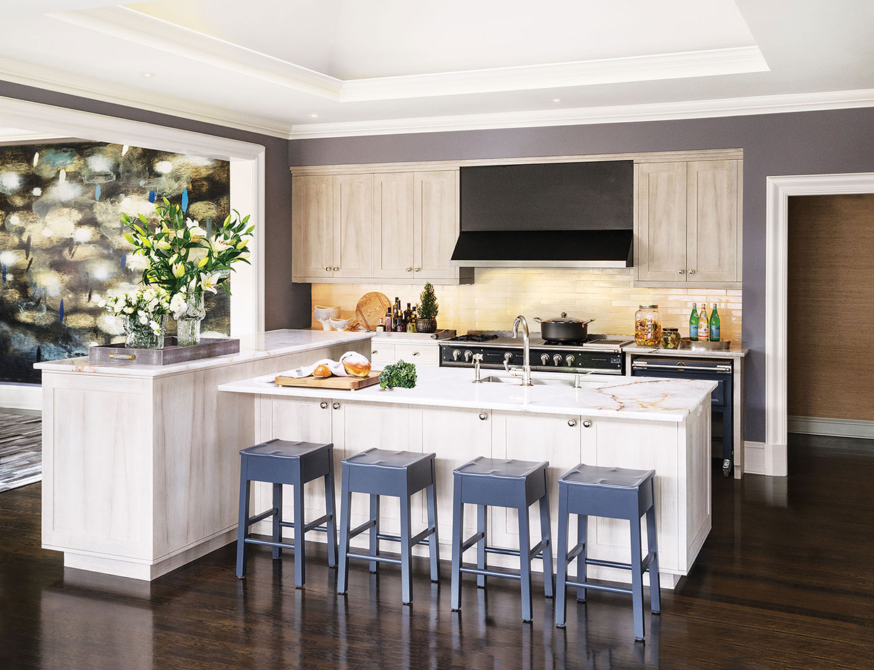 Painted wood stools by San Diego-based artisan Roy McMakin carry the home’s color palette and elegant simplicity into the kitchen. The workspace layout is efficient, and the doorway leads to a pantry, laundry and outer wing of the home.