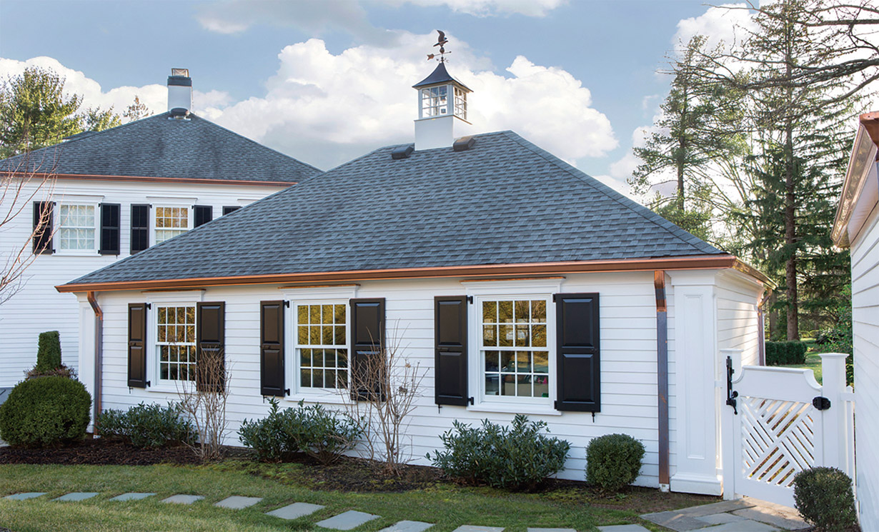 The rear facade of the garage, like the front, was enhanced with new shutters, copper drainpipes and trim above the windows.