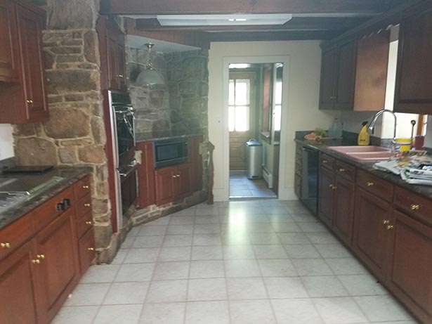 Before: The existing kitchen was in the center of the original farmhouse. While it had wonderful
                original beams and stone walls, it was dark and closed off from the rest of the house.