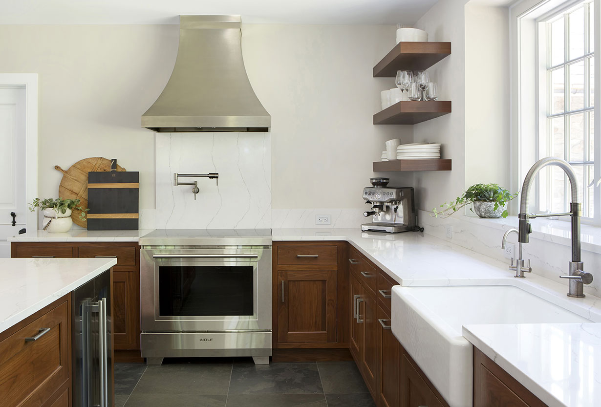 While the kitchen’s clean-lined and uncluttered look leans modern, the materials, millwork and windows honor the historic architecture of the farmhouse.