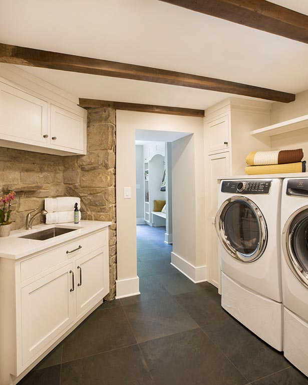 After: In the new laundry room, Wentzel kept the original beams and stone walls intact. The sink is
                located where the microwave is in the previous photo.