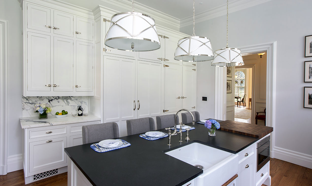 Gorgeous materials were hand-picked for creating this inviting space, including Black Absolute Leathered granite on the island and Breccia Capraia marble for the backsplash.