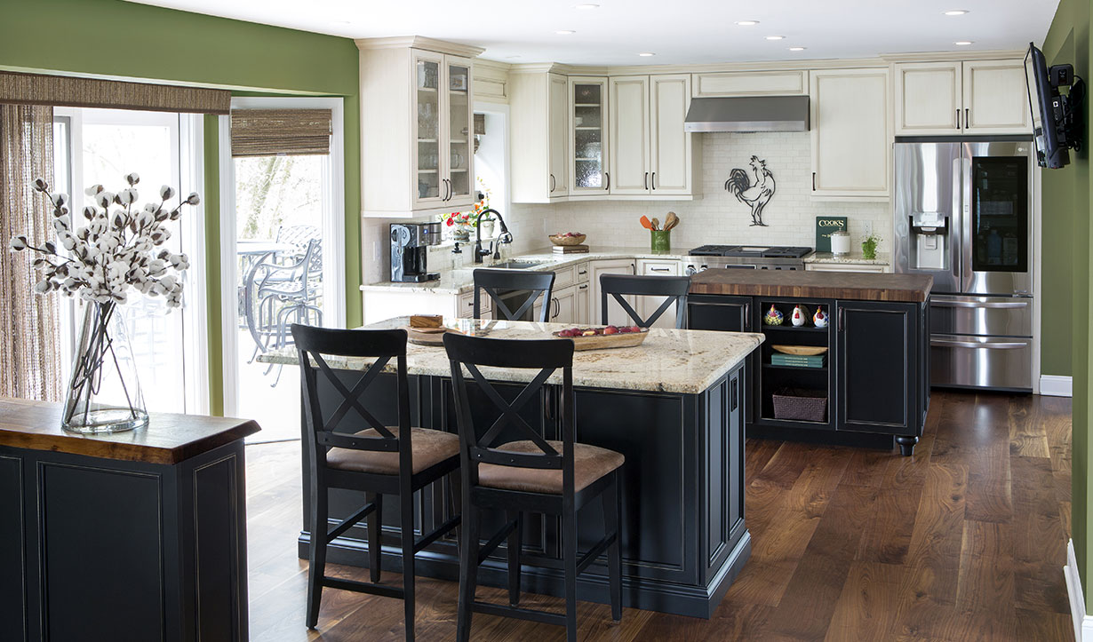 The kitchen renovation includes custom cabinets, a new island with gorgeous butcher block workstation and a second island with shelving, storage and seating.